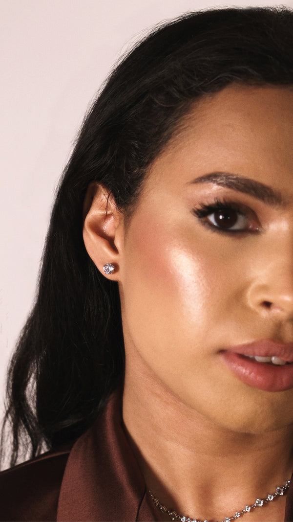 Close-up of a woman's ear with a 1ct stud earring against a neutral background