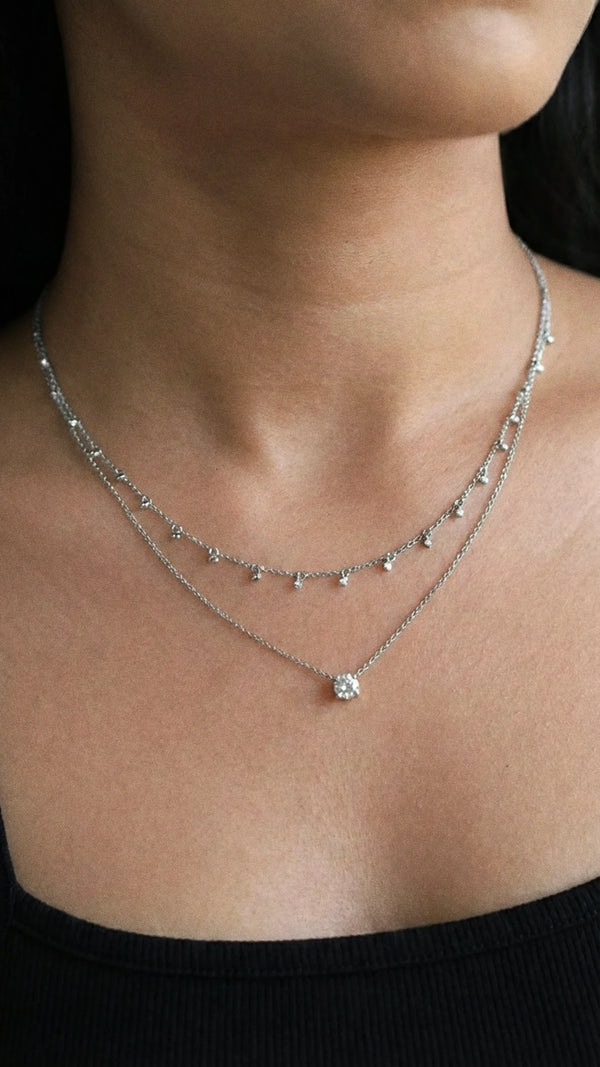 Woman wearing the Ava necklace, a tangle-free adjustable slider necklace with bezel-set stones and solitaire.