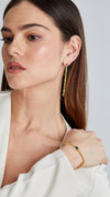 Gold slider bracelet with emerald center stone paired with Cassidy emerald drop earrings