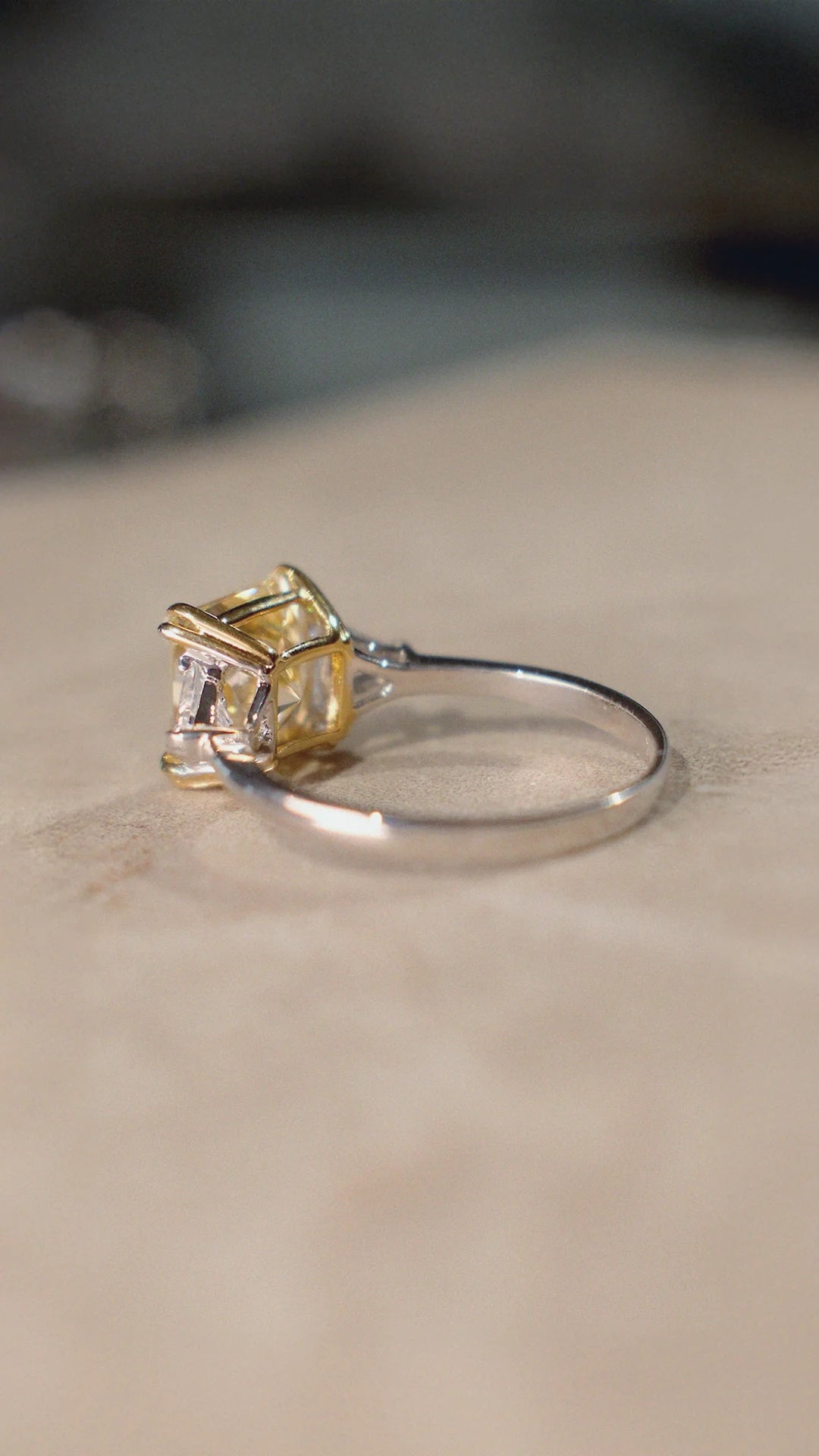 Sterling silver trilogy ring with a light yellow centre stone and sparkling side  stones. 