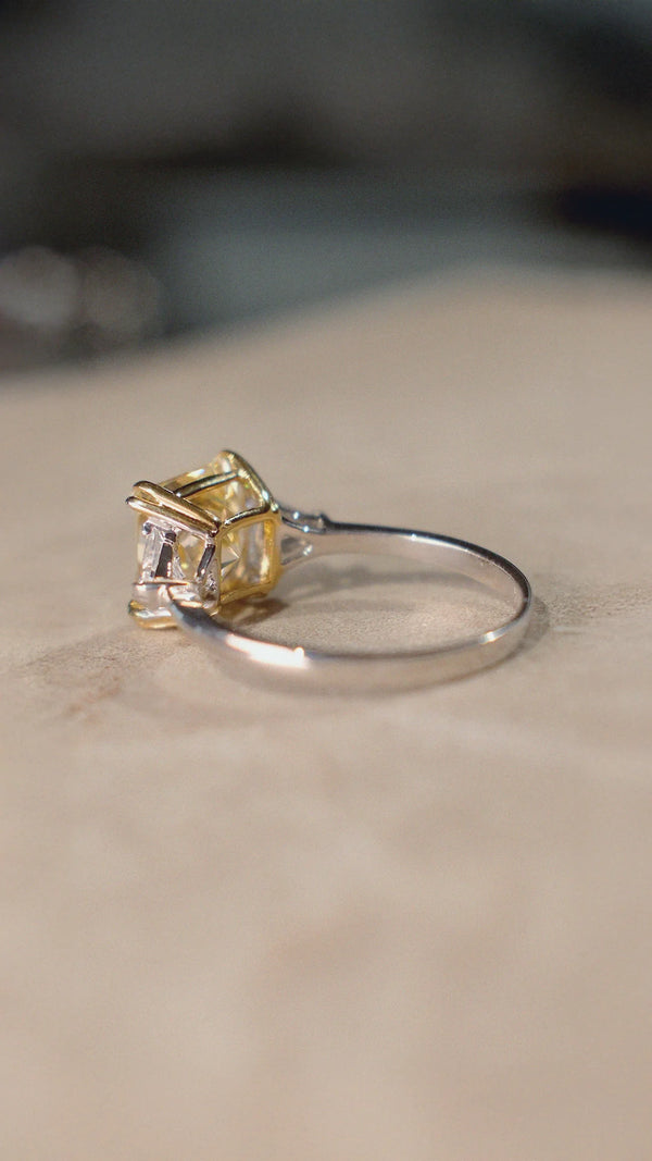 Sterling silver trilogy ring with a light yellow centre stone and sparkling side  stones. 