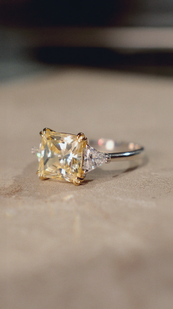 Light yellow princess cut trilogy ring for women with sterling silver band.