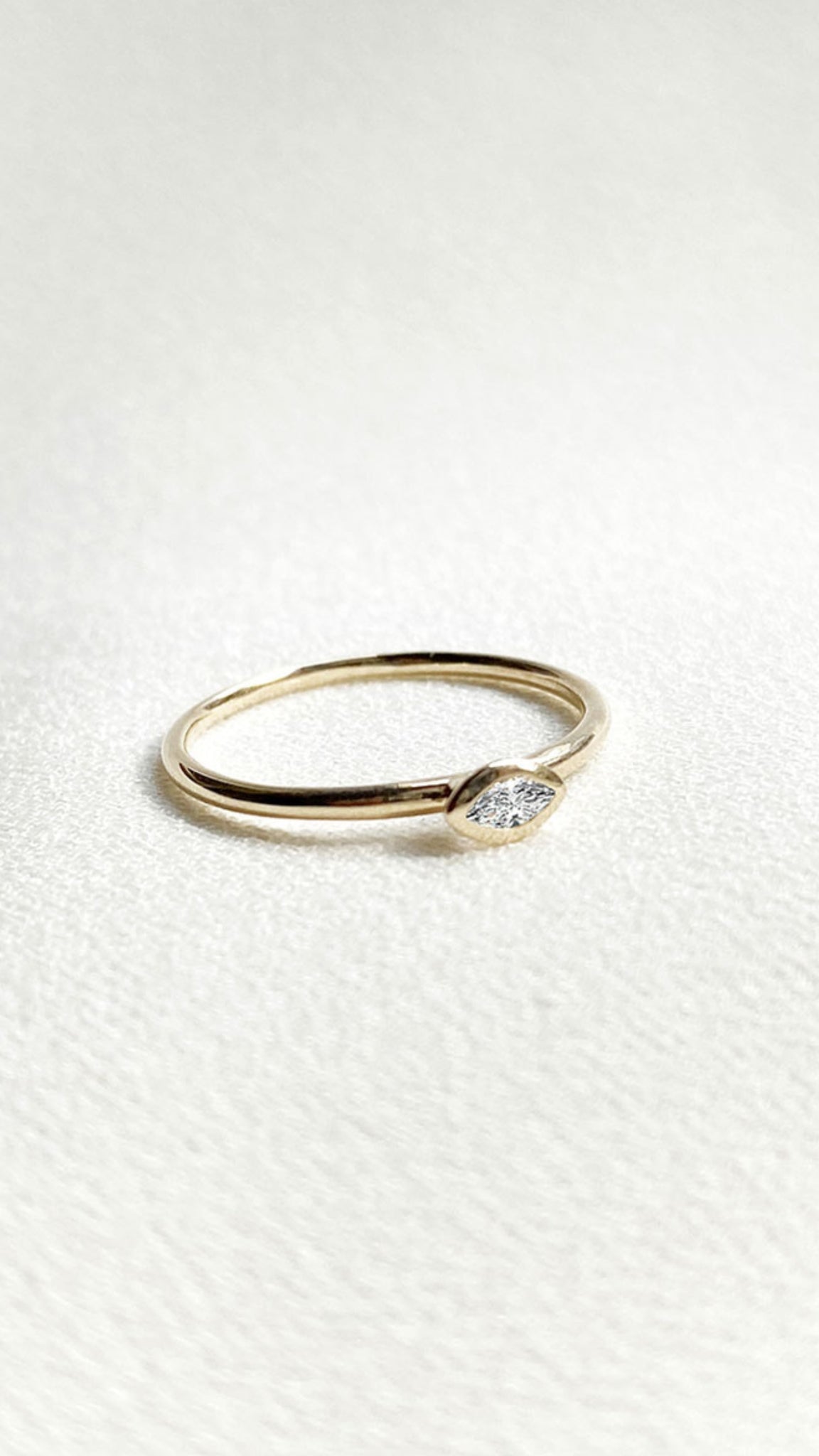 Minimalist solid gold ring with lab grown marquise diamond.