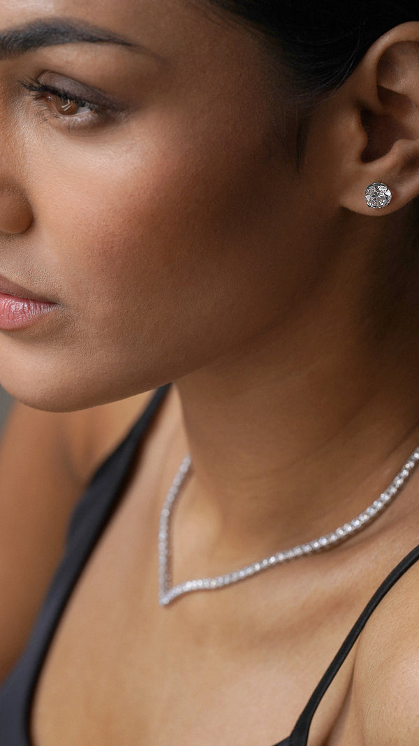 White gold stud earring with a vee line tennis necklace.