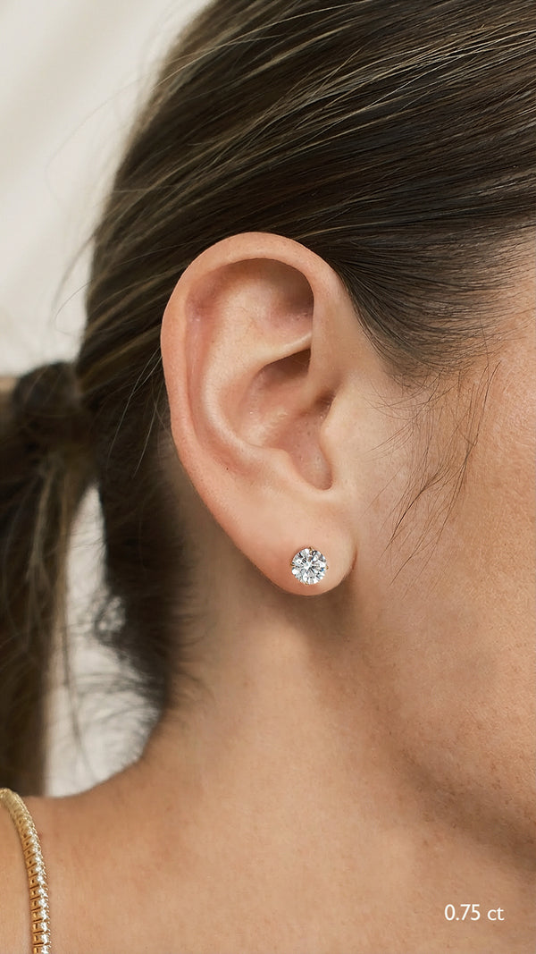 Close-up of an ear wearing a diamond style 0.75ct stud earring with a blurred background