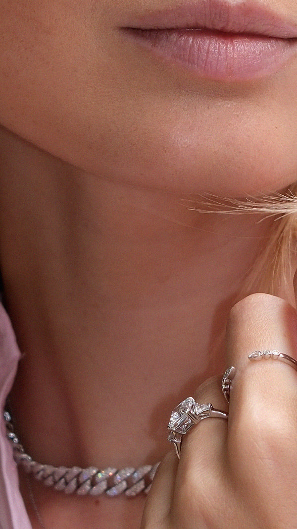 Close-up of a woman's wearing two sterling silver rings with diamond style accents.