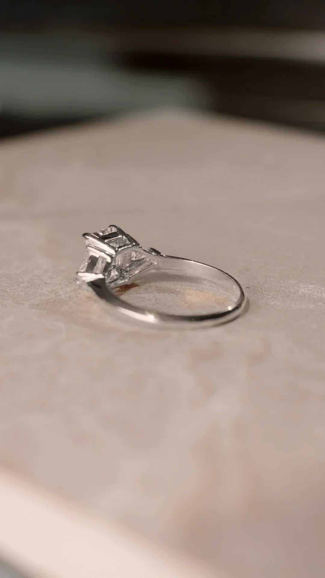 Sterling silver ring with a trilogy design and radiant cut gemstone with triangular side stones.