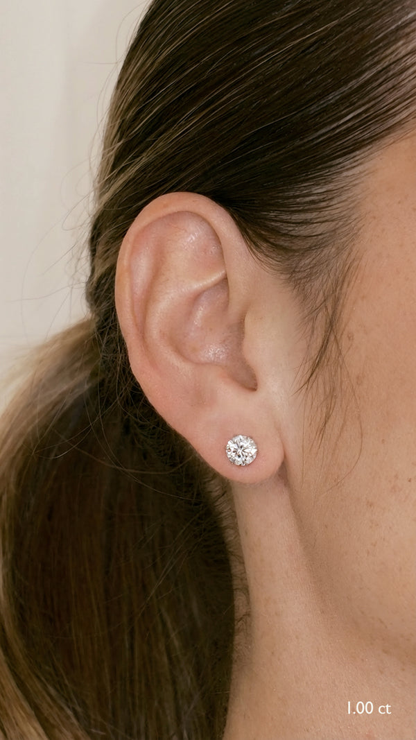 Close-up of an ear wearing a diamond style 1ct stud earring in white gold