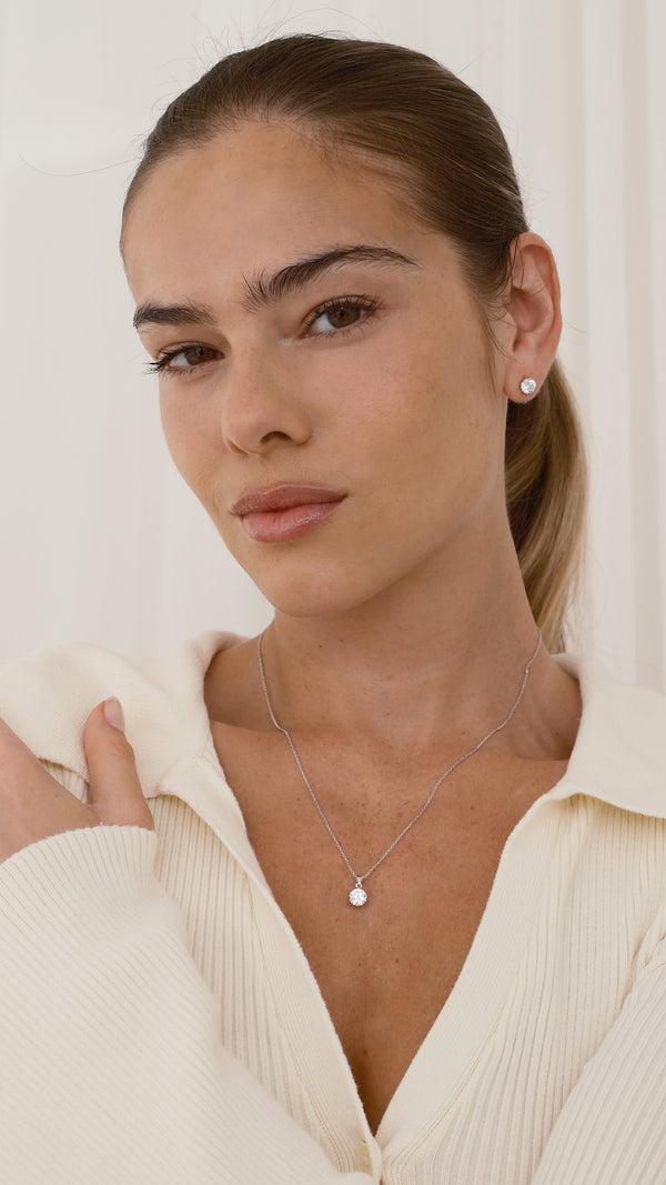 Woman wearing 1ct stud diamond style earrings with matching 9k solid gold pendant necklace. 