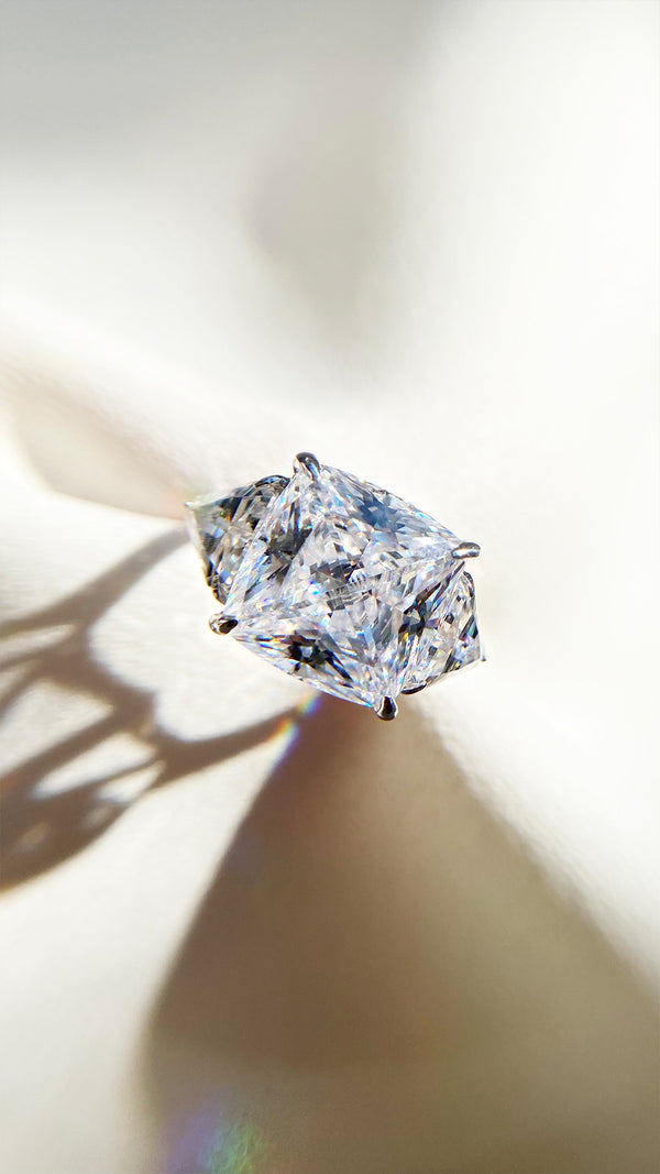 High-brilliance cushion cut trilogy ring with 7 carat equivalent centre stone.