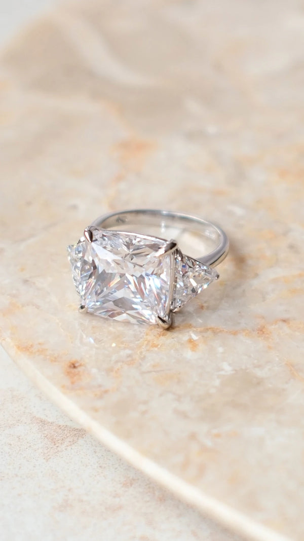 Detailed view of the Gemma trilogy ring's cushion cut facets and silver setting.