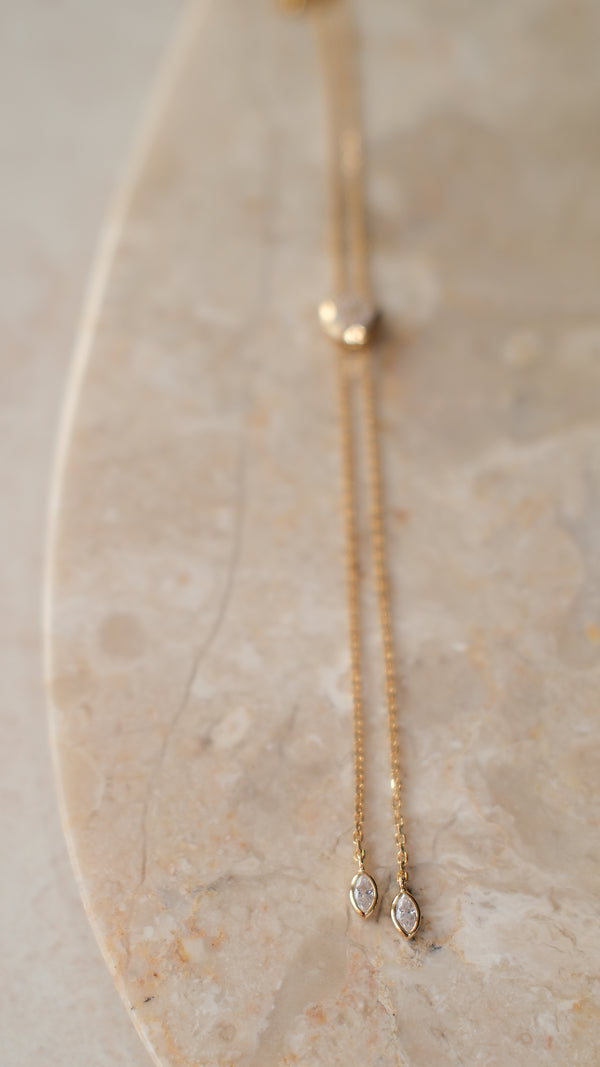 Delicate gold necklace with small gemstones on the end