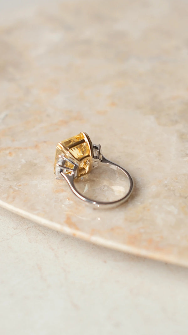 Back view of a fancy yellow radiant cut cocktail ring in polished silver.