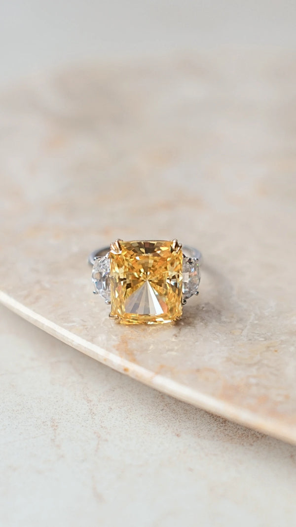 Large fancy yellow radiant cut ring with two half-moon side stones in sterling silver.