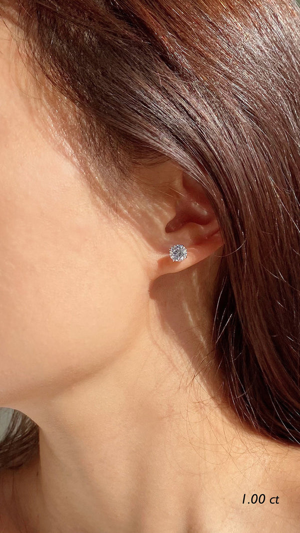 Lab grown diamond 1ct stud earrings for women on a models ear.