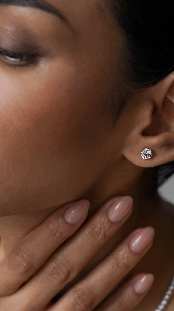 Close-up of a woman wearing a lab diamond earring with a blurred background