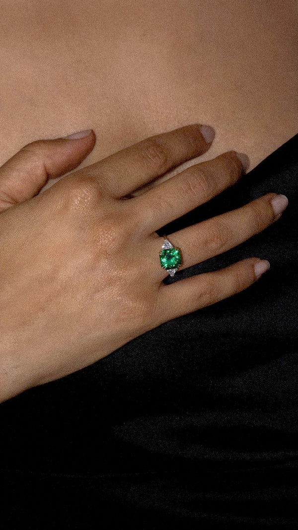 Flanders cut emerald green cocktail ring accented with white side stones