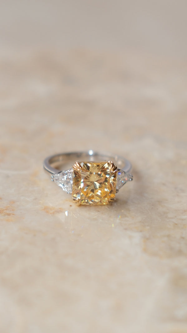Close-up of a yellow flanders cut trilogy ring in sterling silver.