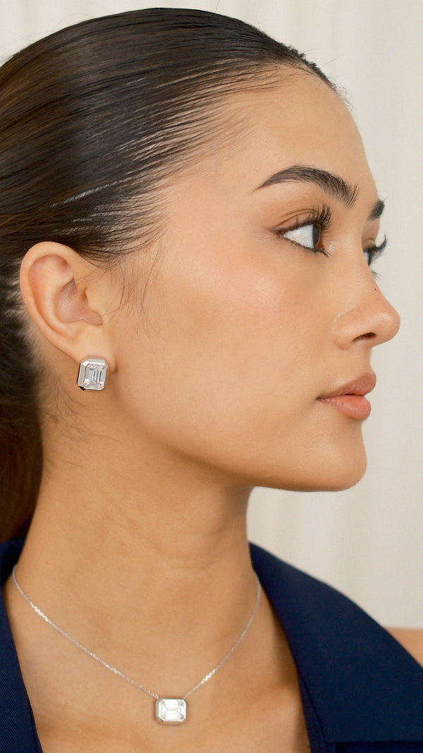 Large white emerald-cut keystone earrings in a thick sterling silver bezel setting
