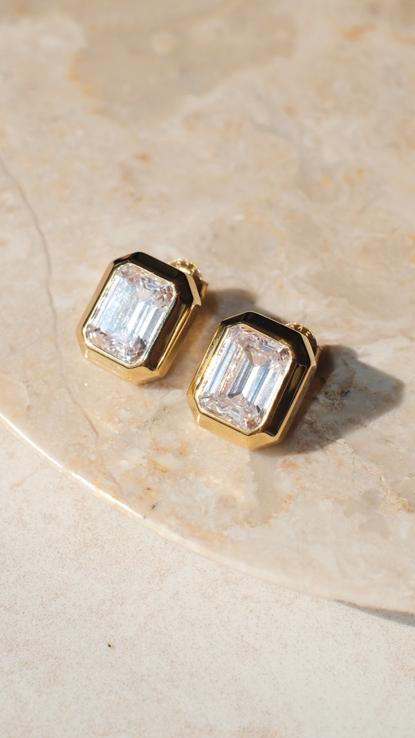 Durable gold-plated statement earring with a secure fit featuring an emerald cut gemstone and 18k gold vermeil bezel setting.
