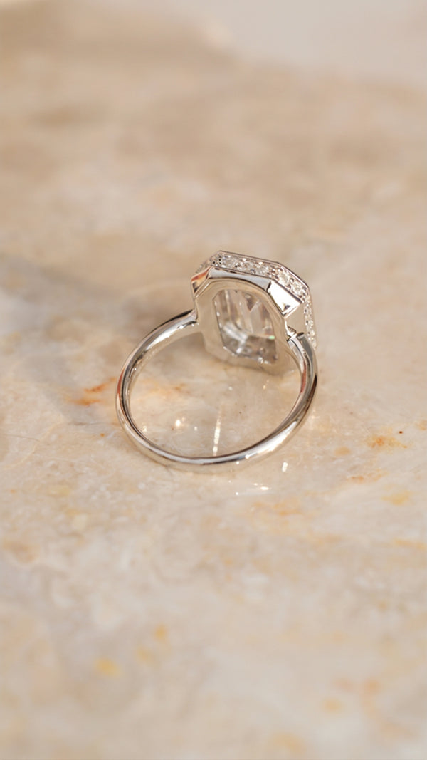 Back-view of the silver Lily ring, showcasing the open-back gallery and the hidden pavé halo of small white gemstones set into the base of the chunky gold bezel.