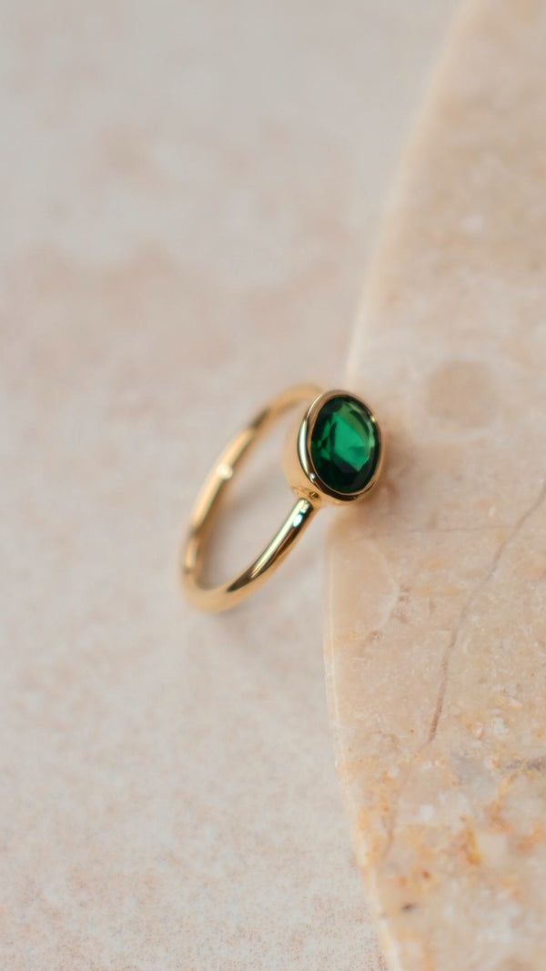 Minimalist bezel set emerald green gemstone ring with oval cut emerald and gold vermeil on sterling silver band