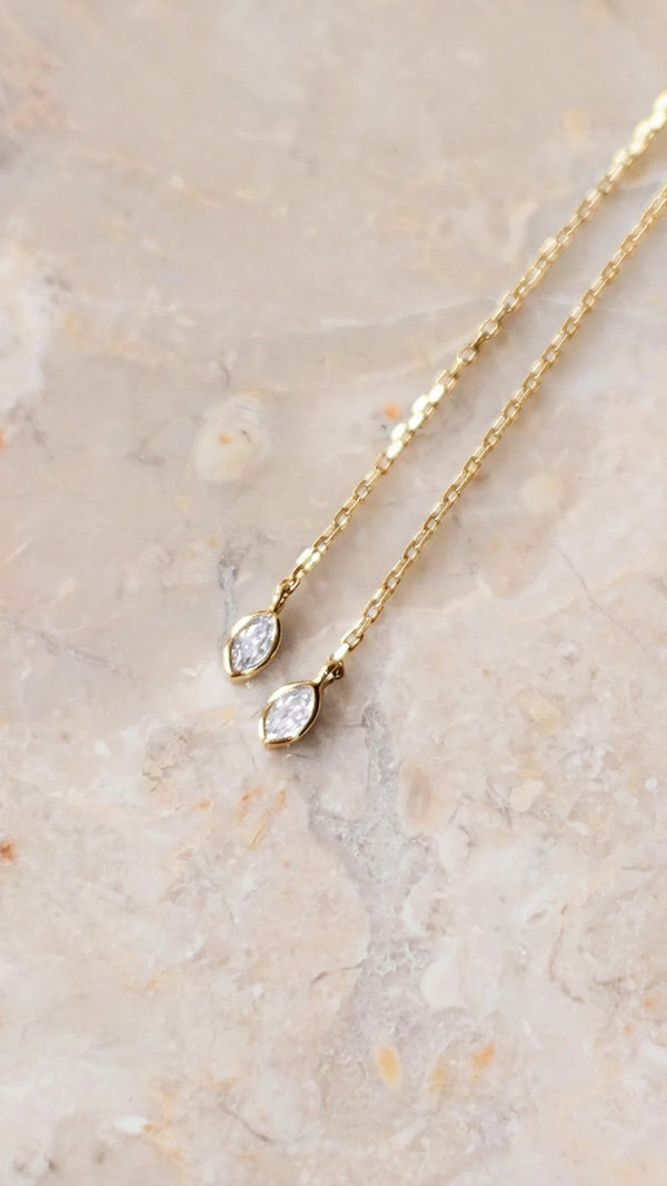 Close-up of sparkling gold layered station necklace adjustable slider gemstone ends. 