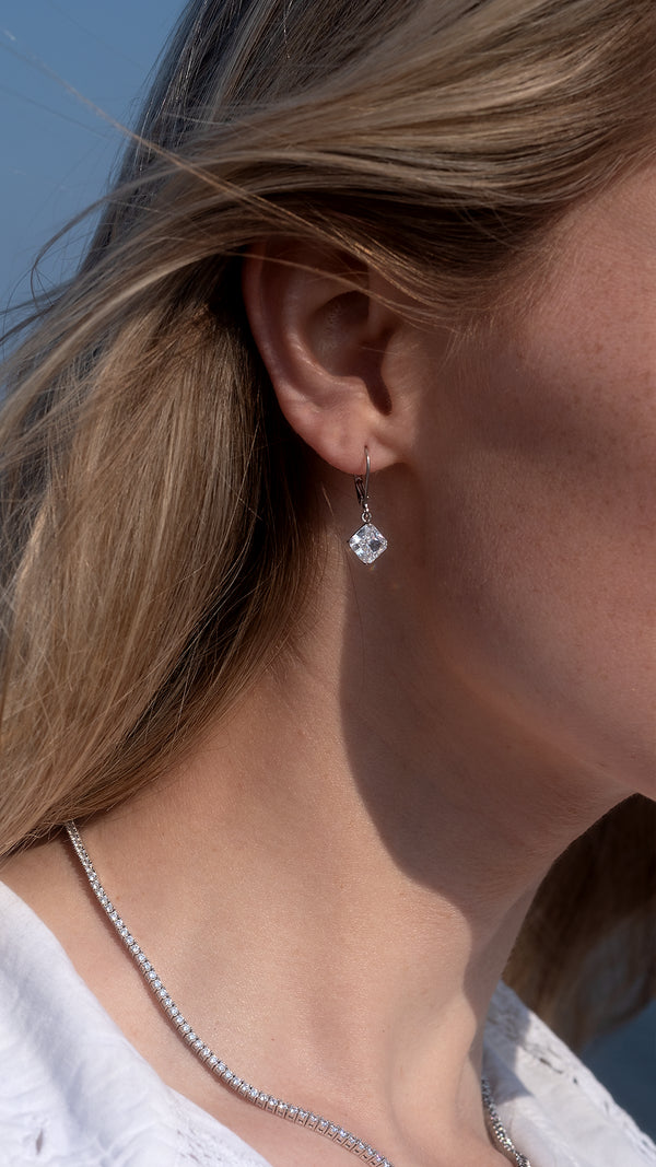 Timeless sterling silver earrings featuring polished princess-cut solitaire drops