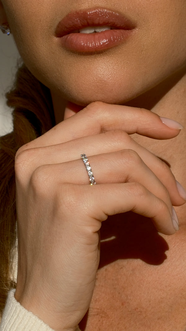 Close-up of a hand wearing a 9k solid white gold eternity ring.