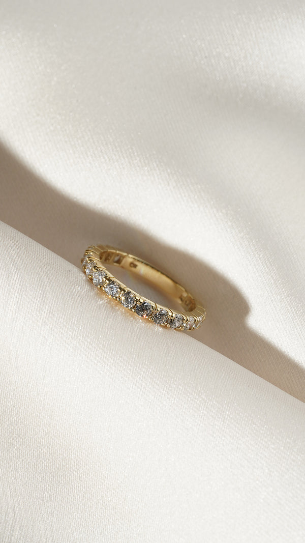 Side profile of the Raina 9k solid gold eternity ring with a row of round gemstones. 