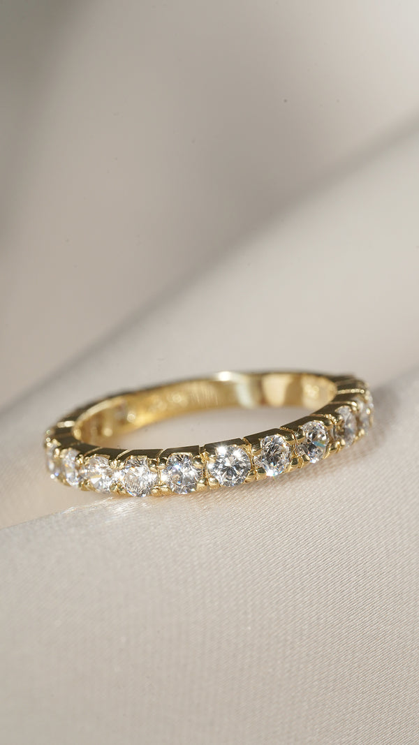 Close up of a diamond style 9k solid yellow gold eternity ring for women.