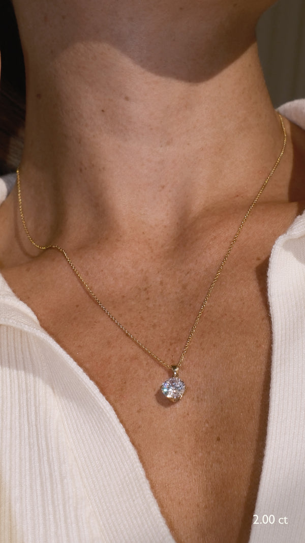 Close-up of a person wearing a 9k solid gold necklace with a diamond style 2ct pendant.