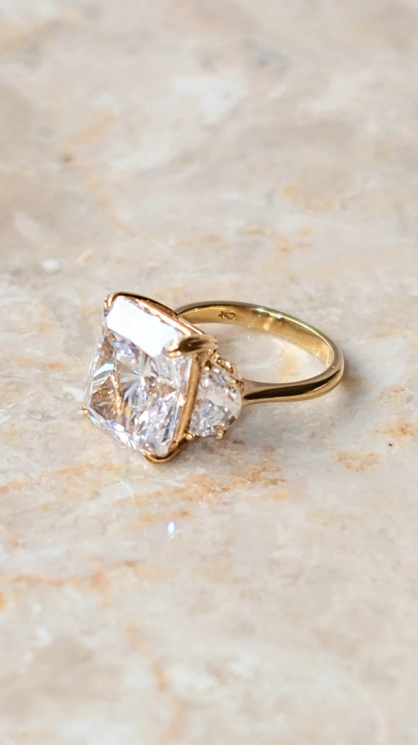 Close-up of the half-moon side stones on a gold vermeil radiant cut ring