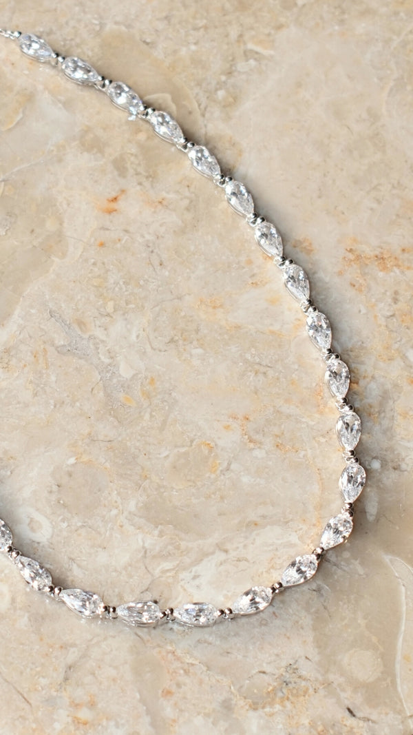 Sterling silver tennis style slider necklace featuring pear-cut stones that evoke raindrops in motion.