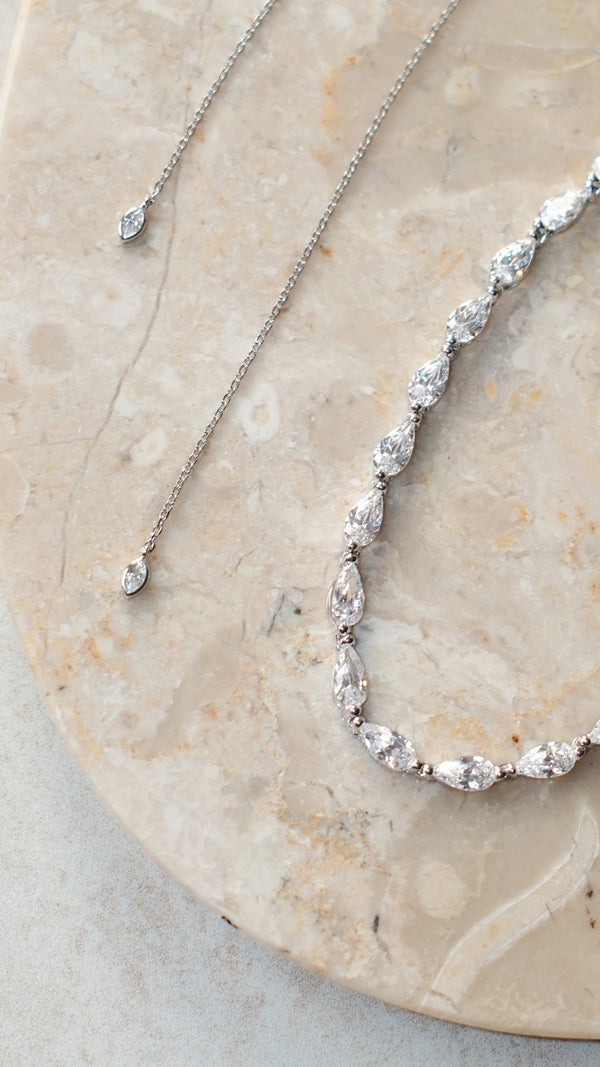 Detail of adjustable slider chain on sterling silver tennis necklace with marquise-tipped ends.