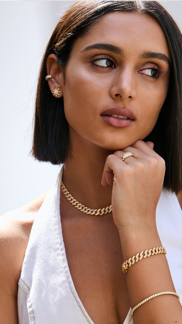 Vida gold Cuban bracelet layered effortlessly with a gold tennis bracelet and chunky cuban chain necklace.