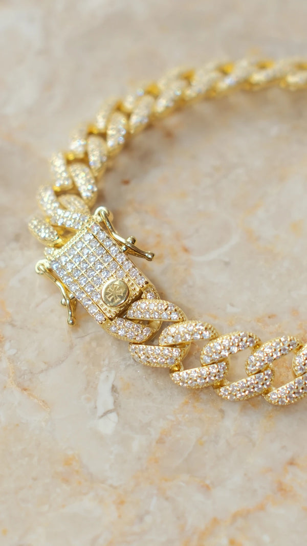 Macro detail of the heavy-duty fastening on the chunky gold Cuban chain.