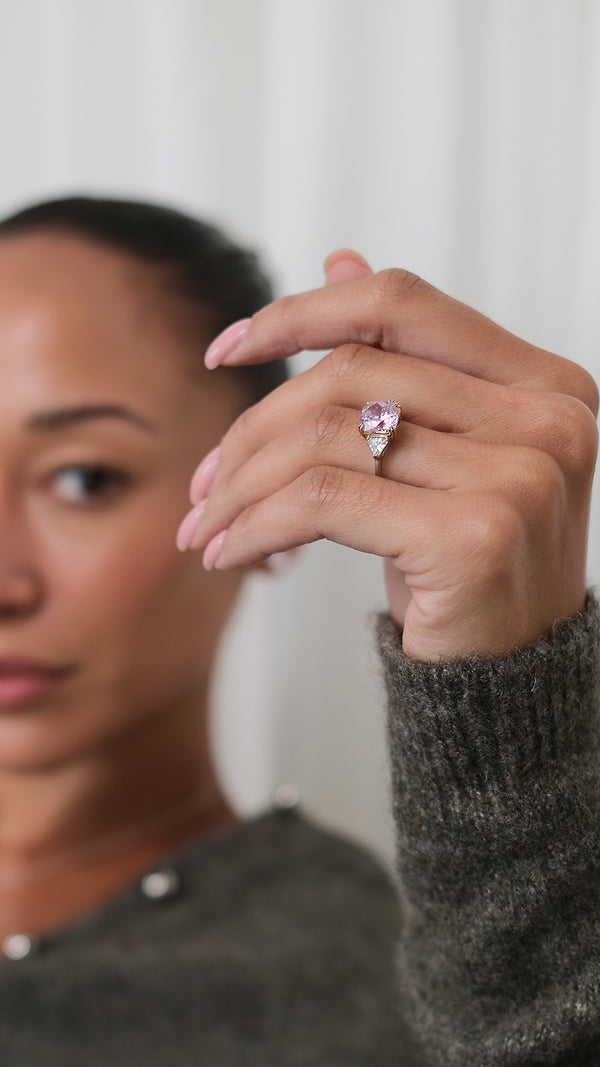 A model's hand wearing a stunning sterling silver baby cocktail ring with a fancy pink 3ct equivalent trilogy centre stone.